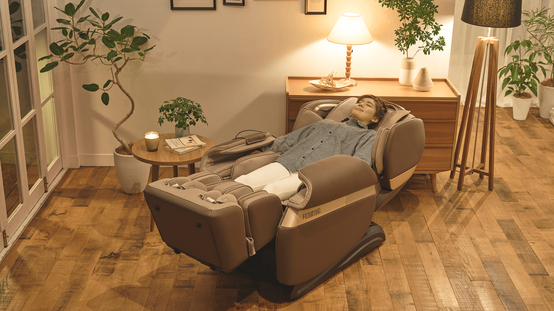 Woman reclines in massage chair in a warmly-lit room