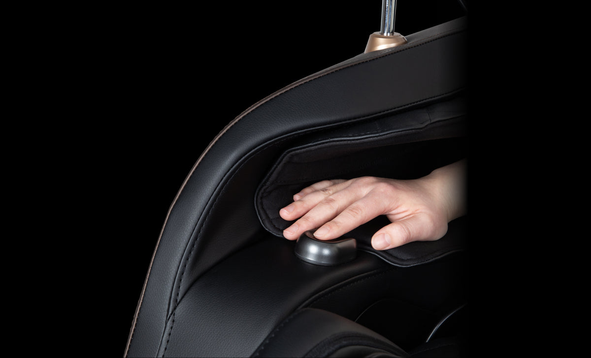 Close-up of a person's finger on the Osaki Duke XL 4D Massage Chair Health Test Sensor against a black background